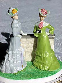 Two Victorian ladies standing by a low wall