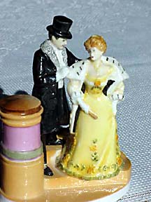 A Victorian gentleman helping a lady with her cape.